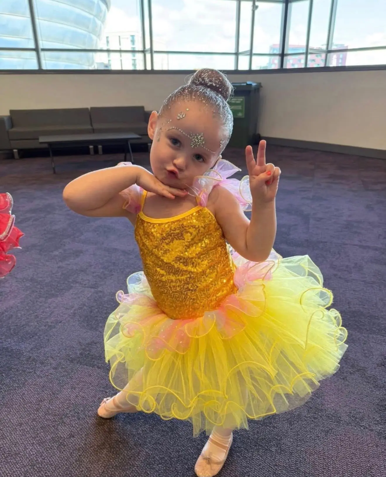 Little ballerina in a yellow sequin tutu posing
